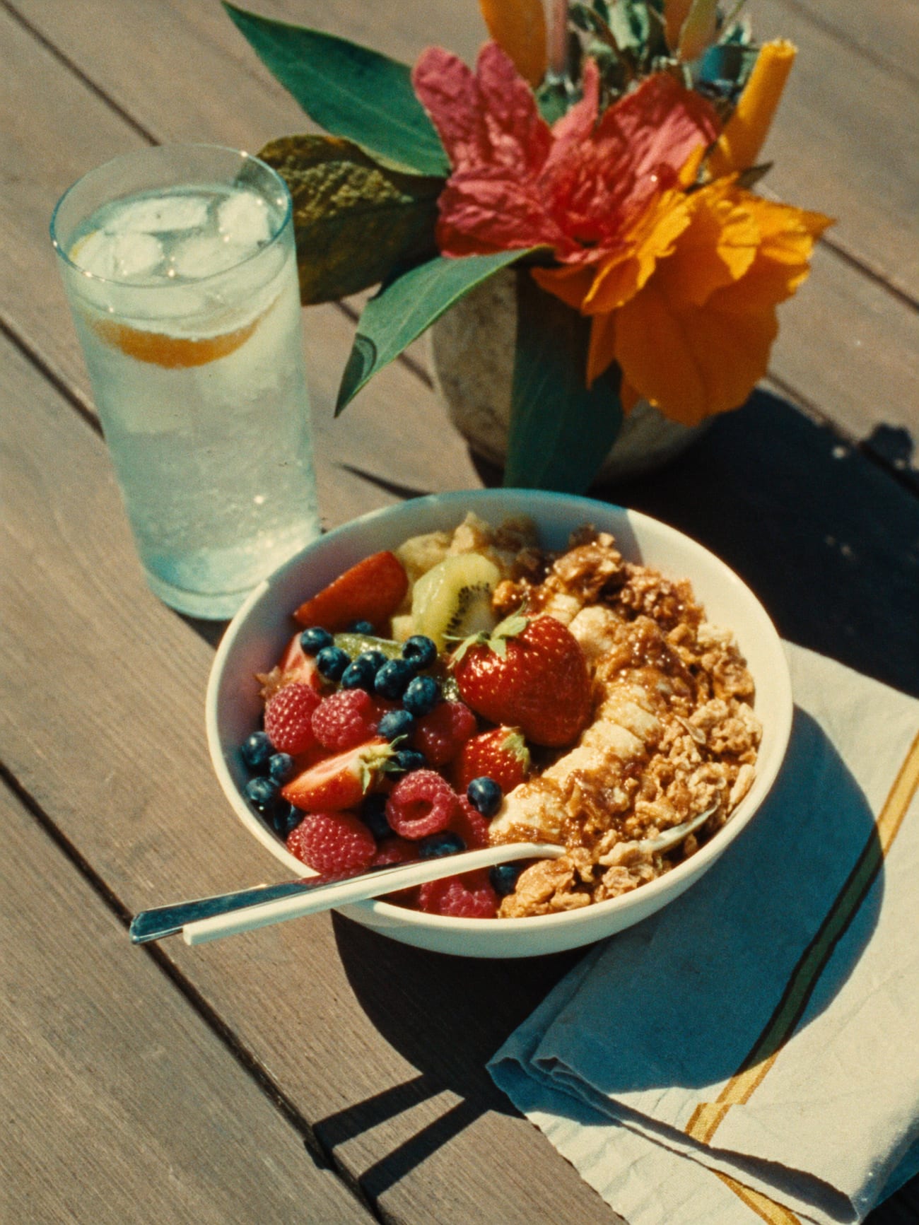Frühstücksbowl mit Beeren und Granola auf einem Holztisch