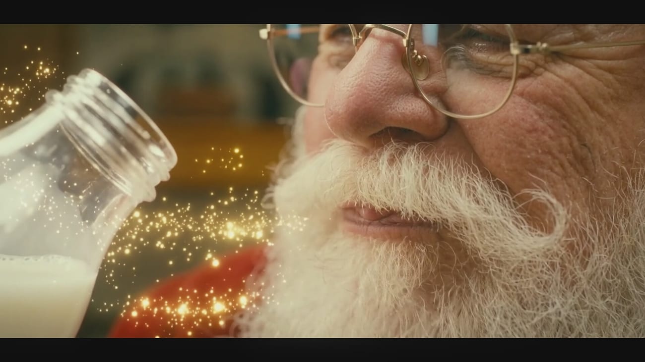Weihnachtsmann trinkt ein Glas Milch am Kamin
